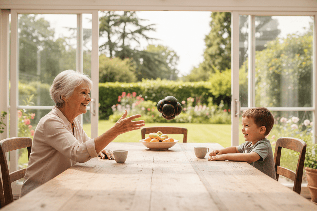 Senior et son petit-fils à une table dans la véranda avec vue sur le jardin, NeuroBall™ 14 cm balle de réflexes multi-sphères en action, exercices d'équilibre et prévention des chutes